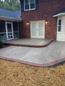 concrete patio with brick border